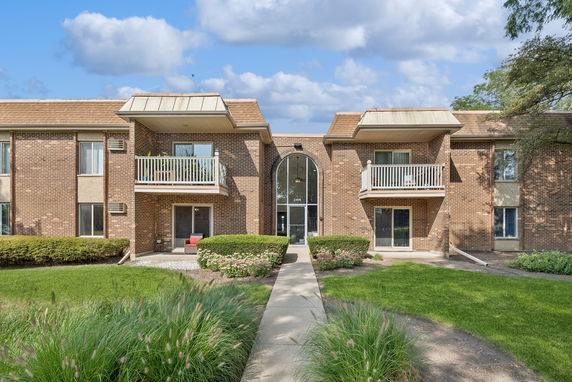 Front view of a two-story brick apartment building with balconies.