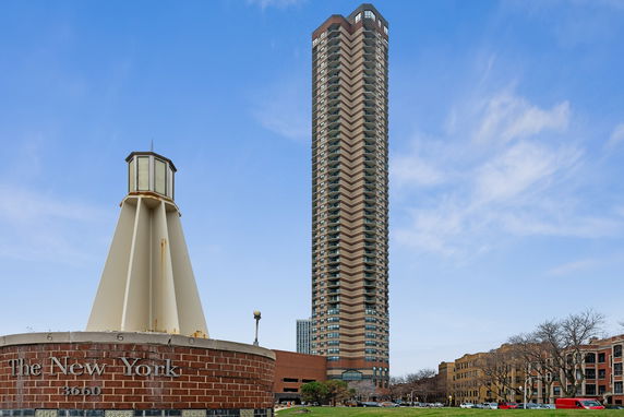 Front view of a tall high-rise building with numerous floors and balconies.
