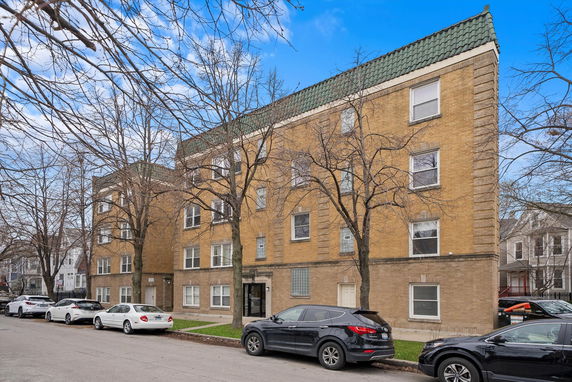 Front view of a multi-story residential building with brick facade.