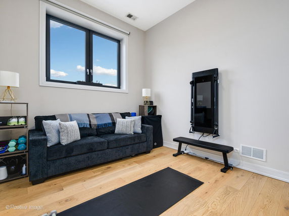 Room with exercise equipment, a bench, and a sofa.