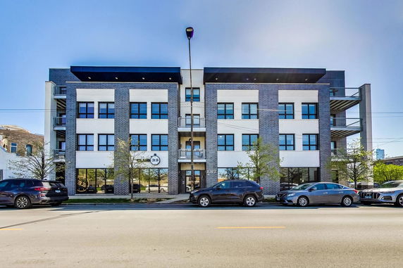 Front view of a multi-story building with brick and white facade.