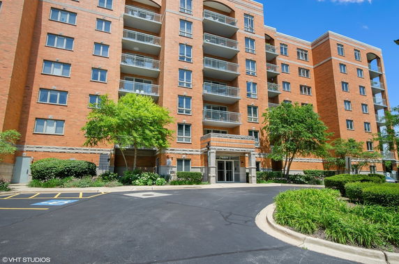 Front view of a multi-story brick apartment building with balconies.