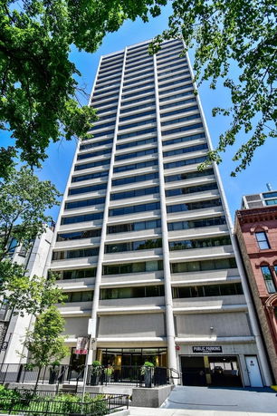 Front view of a tall multi-story building with a public parking entrance.