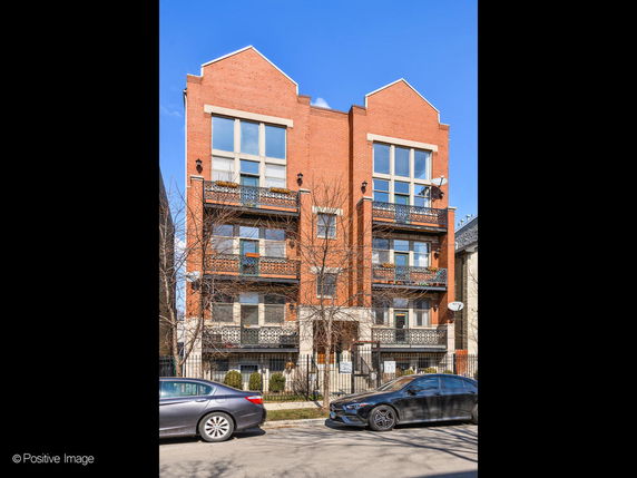 Front view of a multi-story brick building with balconies.
