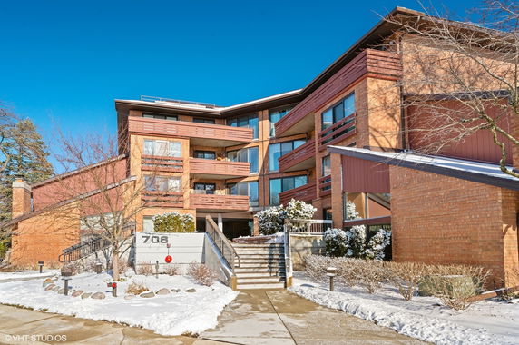 Front view of a multi-story building with brick facade and balconies.