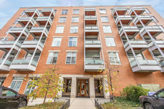Front view of a multi-story apartment building with balconies.