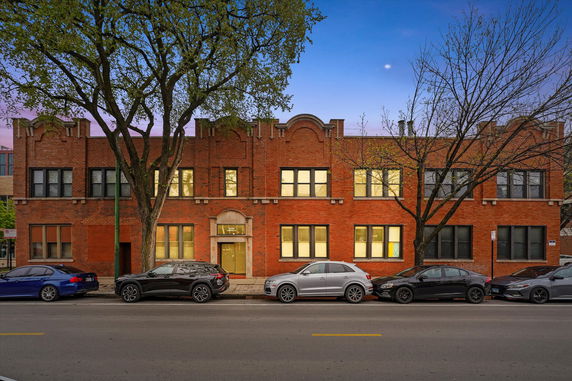 Front view of a two-story brick building with multiple windows and a central entrance.