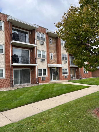 Front view of a multi-story apartment building with balconies.