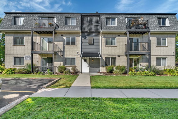Front view of a three-story apartment building with balconies.