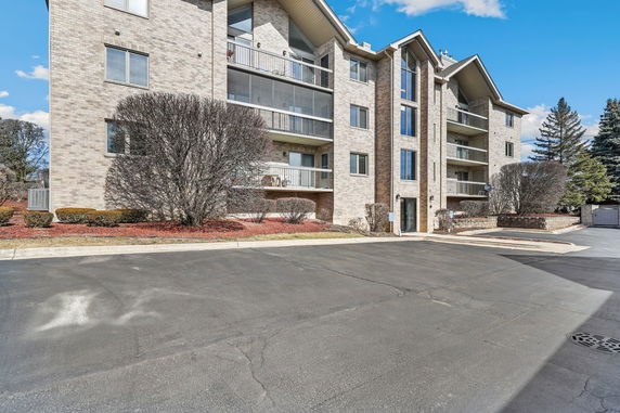 Front view of a multi-story apartment building with balconies.