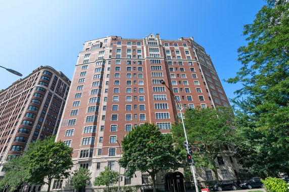 Front view of a tall brick building with multiple windows and a detailed facade.