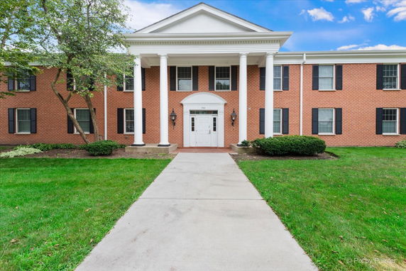 Front view of a two-story building with brick exterior and white columns.