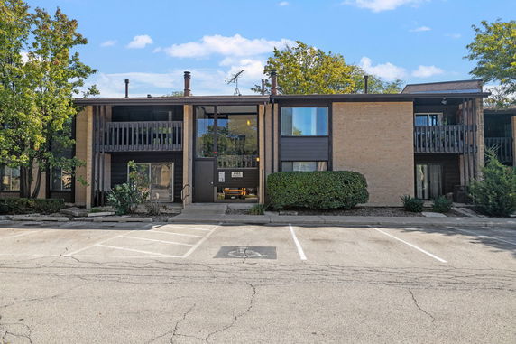 Front view of a two-story apartment building with balconies and a central entrance.