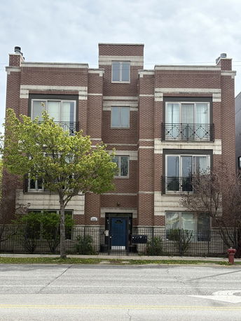 Front view of a multi-story brick building with balconies.
