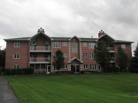 Front view of a multi-story brick apartment building.