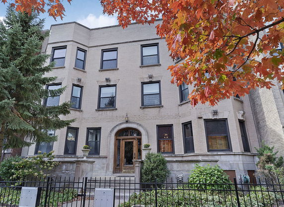 Front view of a three-story apartment building with brick exterior and multiple windows.