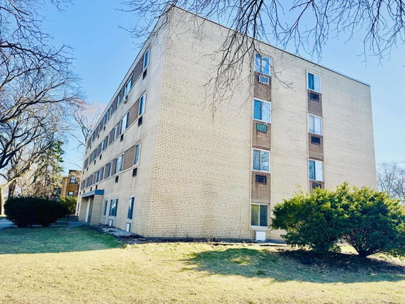 Front view of a multi-story brick apartment building.