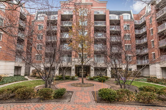 Front view of a multi-story brick apartment building with balconies.