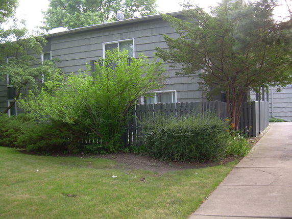 Front view of a two-story building with a fenced yard.