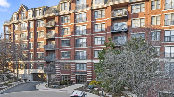 Front view of a multi-story brick residential building with balconies.