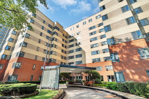 Front view of a multi-story residential building with a covered entrance.
