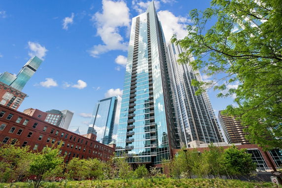 Front view of a modern glass skyscraper in an urban setting.