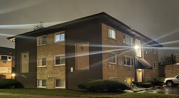 Front view of a two-story brick apartment building at night.