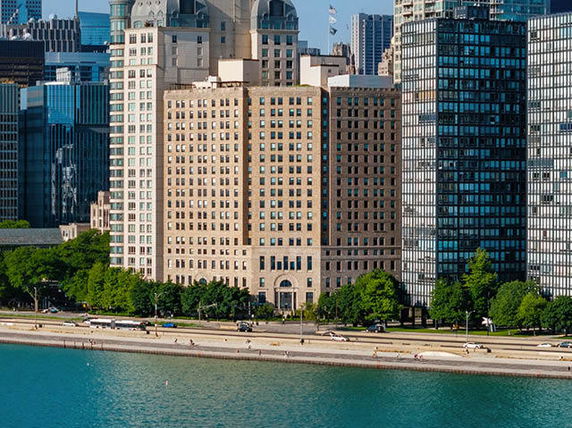 Front view of a tall building with multiple floors next to water.