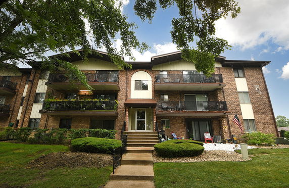 Front view of a multi-story apartment building with balconies.