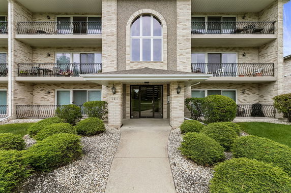 Front view of a multi-story building with balconies and a main entrance.