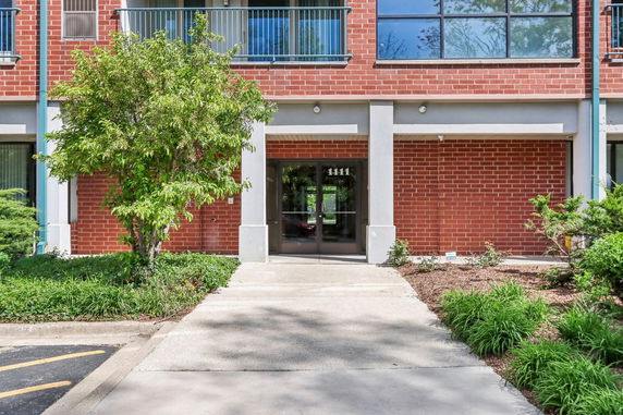 Front view of a brick building with large windows and entrance.