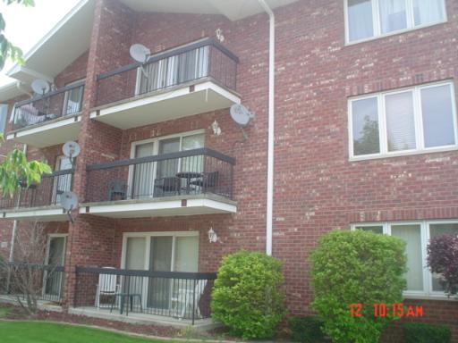 Front view of a brick apartment building with balconies.