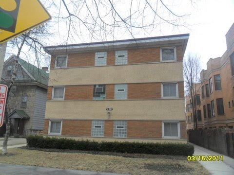 Front view of a three-story apartment building with a flat roof.