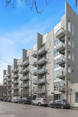 Front view of a multi-story apartment building with balconies.