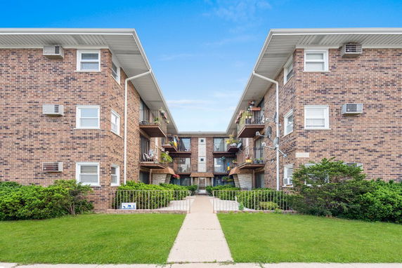Front view of a multi-story brick apartment building.