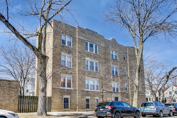 Front view of a four-story brick apartment building.