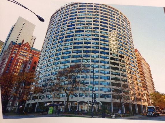 Front view of a tall, curved high-rise building with numerous windows.