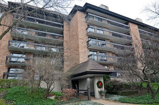 Front view of a multi-story brick apartment building with balconies.