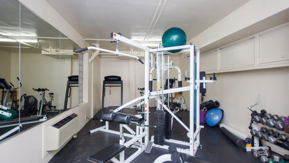 Indoor gym area with exercise equipment and mirrors.