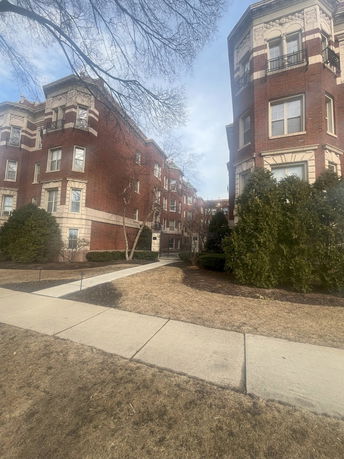 Front view of a multi-story brick building with decorative trim.