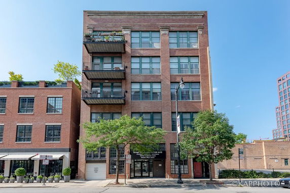 Front view of a multi-story brick building with balconies.
