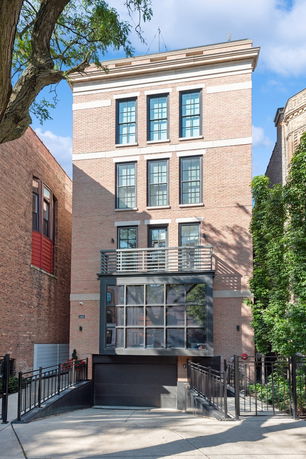 Front view of a multi-story brick building with large windows and a garage.