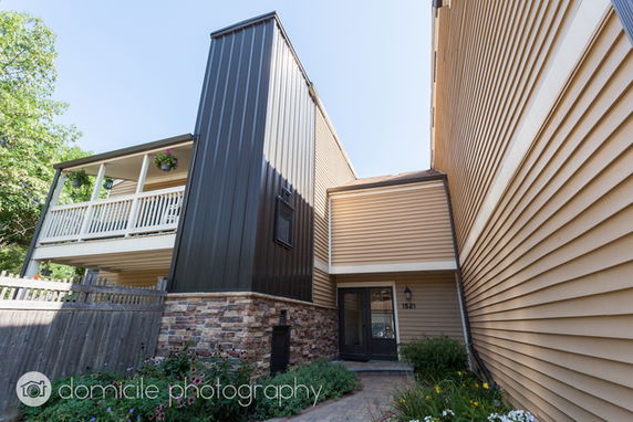 Front view of a multi-story house with a combination of siding and stone facade.