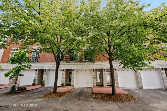 Front view of a townhouse with multiple garages and brick facade.