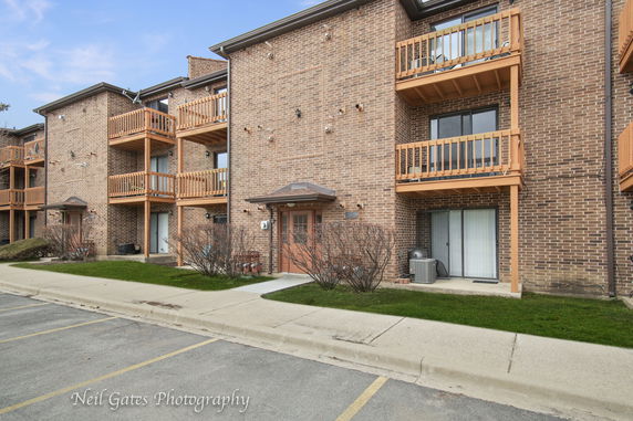 Front view of a brick apartment building with balconies.