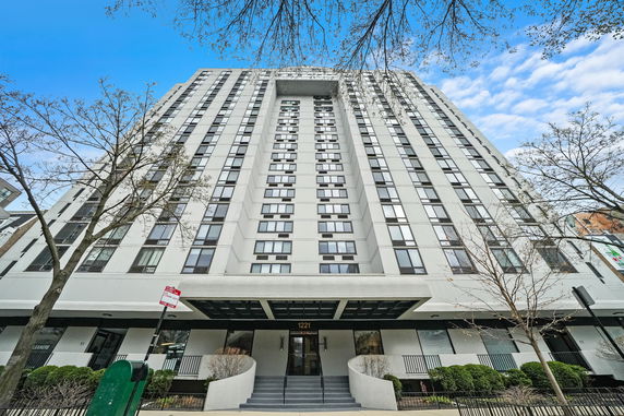 Front view of a multi-story building with numerous windows and a central entrance.