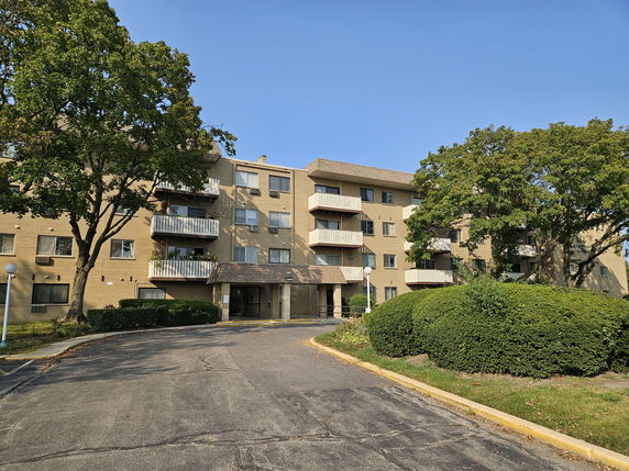 Front view of a multi-story apartment building with balconies.