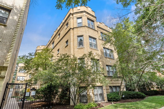 Front view of a multi-story brick building with numerous windows.