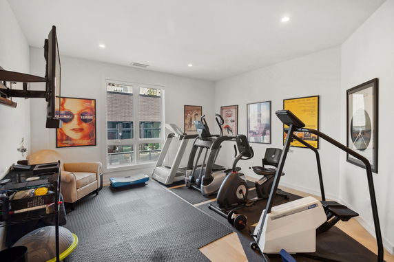 Indoor gym area with exercise equipment and posters on the walls.
