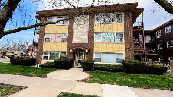 Front view of a three-story apartment building with a central entrance.